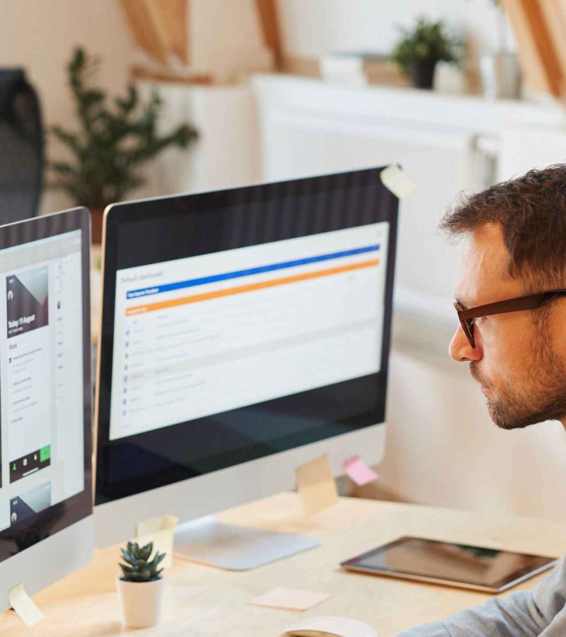 webentwickler Ein Webentwickler sitz an seinem Schreibtisch und updatet eine Webseite.