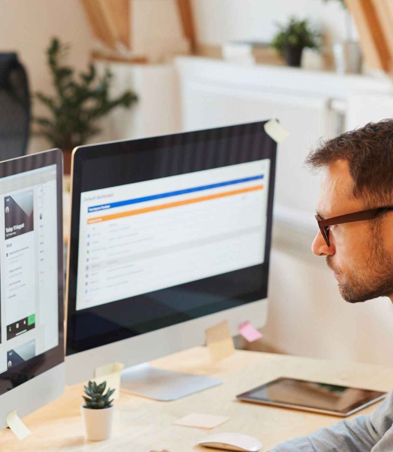 Ein Webentwickler sitz an seinem Schreibtisch und updatet eine Webseite.