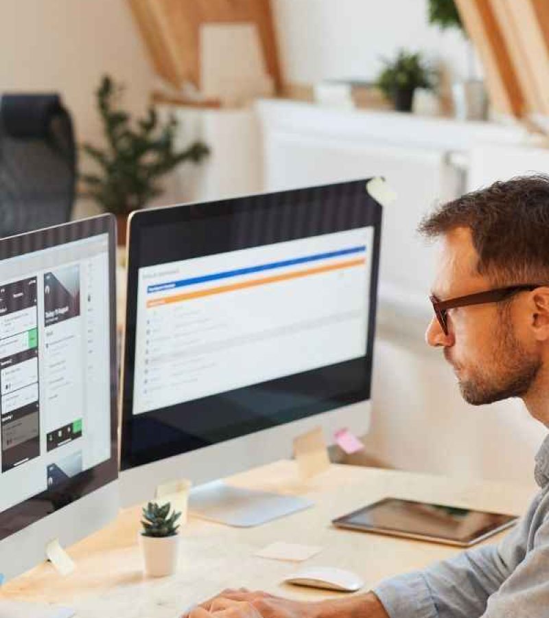 Ein Webentwickler sitz an seinem Schreibtisch und updatet eine Webseite.